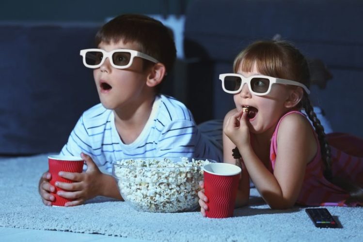 children in 3D glasses watching movie at home