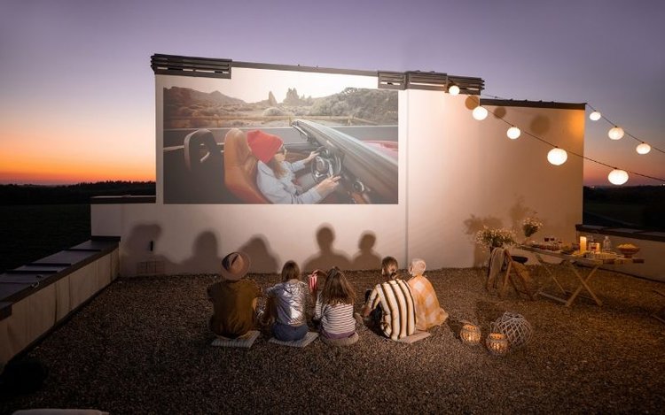 group of five people watching films outdoor
