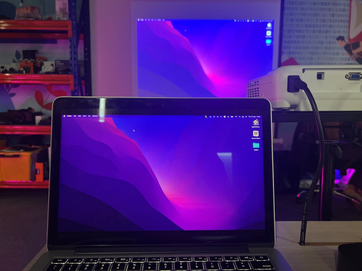 A MacBook is screen mirroring to Epson projector and showing the home screen