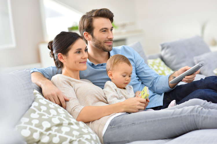 A family watching TV together with a baby