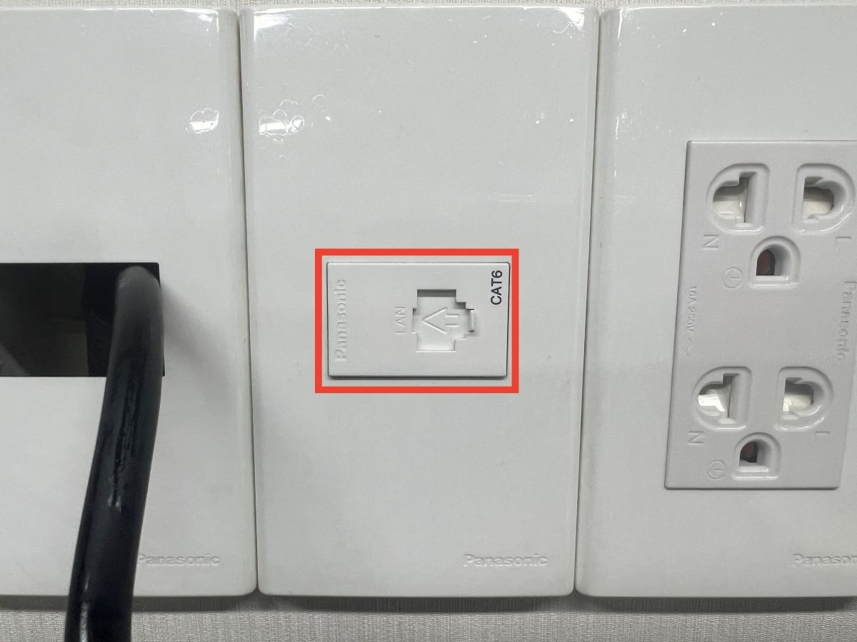 The CAT6 port on a wall alongside with the power outlets
