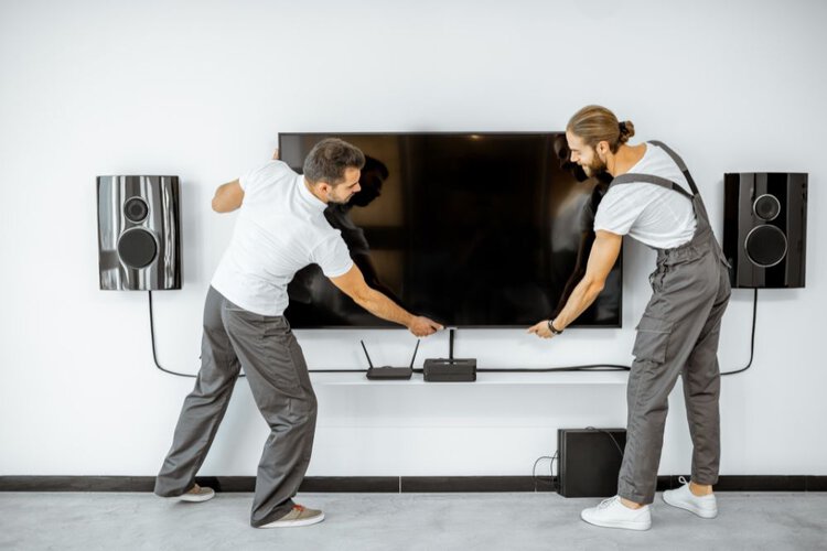Two man moving a plasma TV