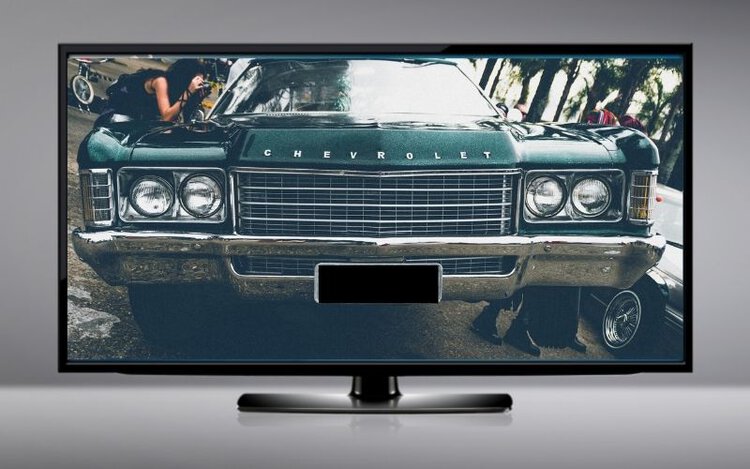 a TV with an image of car that is hidden the license plate