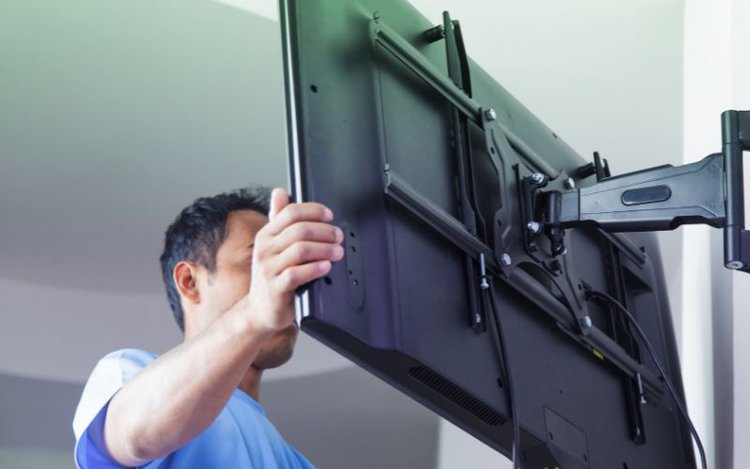 a man mounting a TV