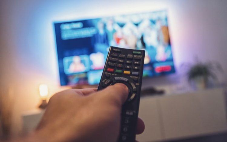 a person inspects the remote of a TV