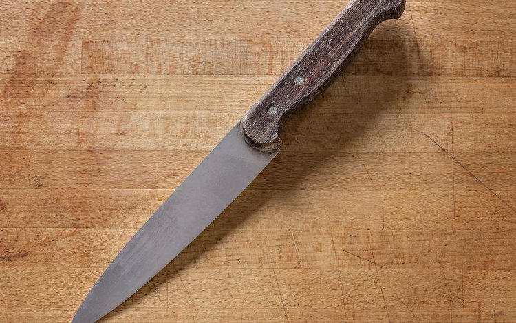 a sharp knife on a wooden board