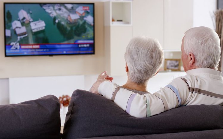Una pareja de ancianos disfruta viendo televisión sin internet
