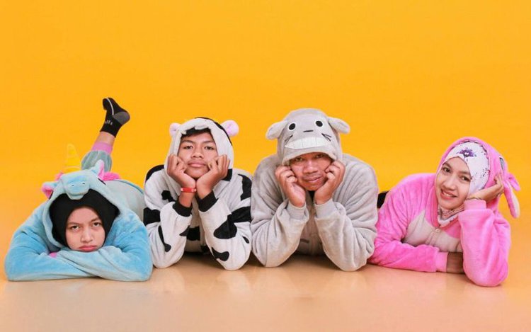 four friends wearing onesies