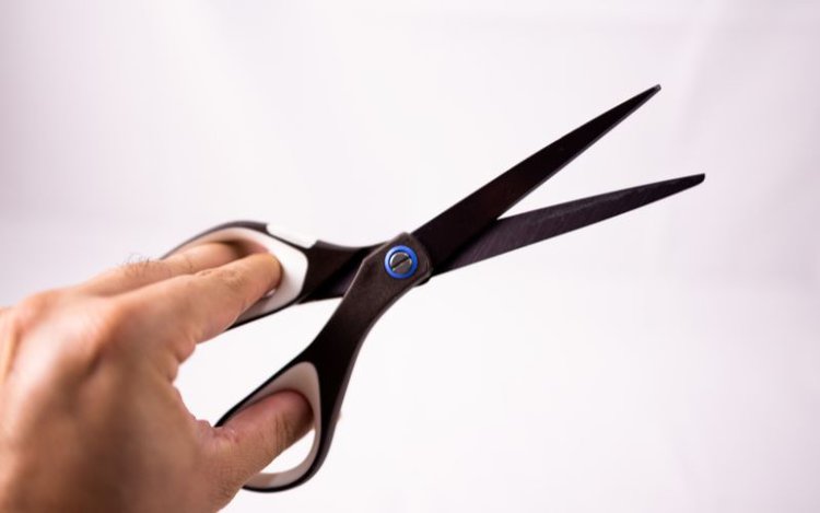 man holding a pair of black scissor