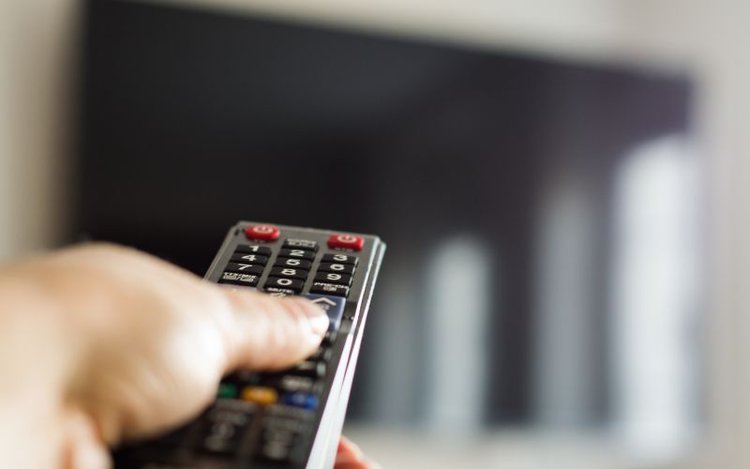 man resets his TV with a remote control