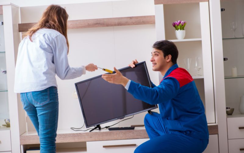 man talking with a girl to repair a TV
