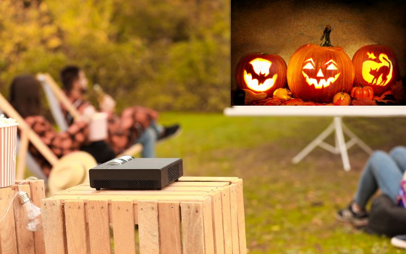 projector showing Halloween pumpkins in a backyard