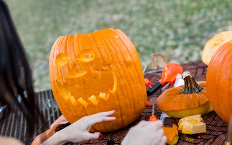 woman carving pumpkin for Halloween