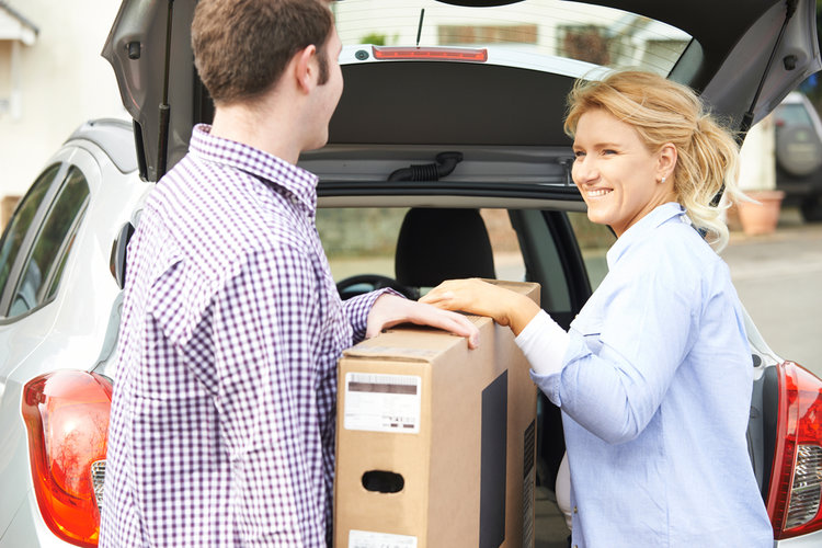 A couple moving a TV by car