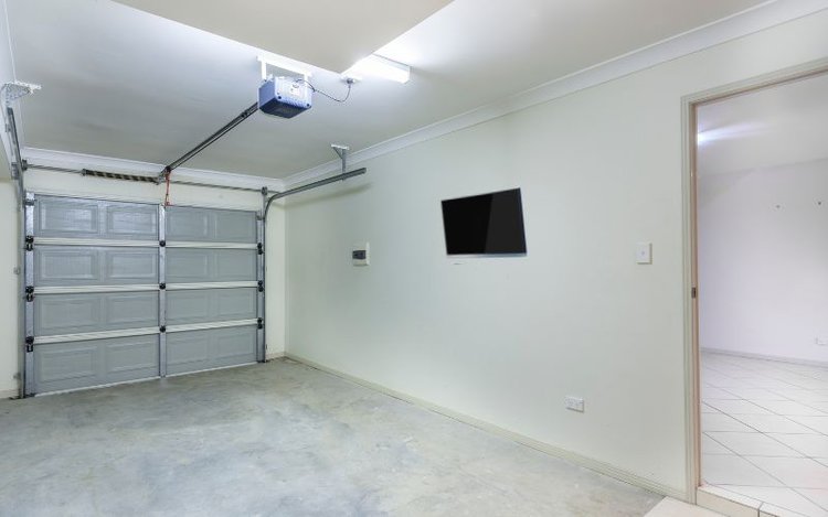TV is mounted on a wall in the home garage