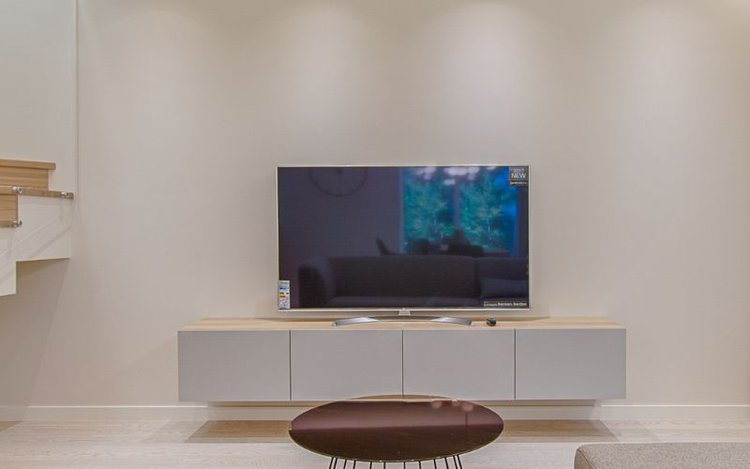 a TV is placed near to the wall to avoid falling