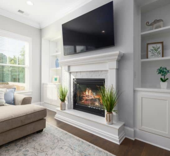 a black TV mount over a fireplace in bright living room