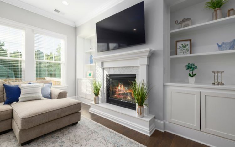 a black TV mount over a fireplace in bright living room