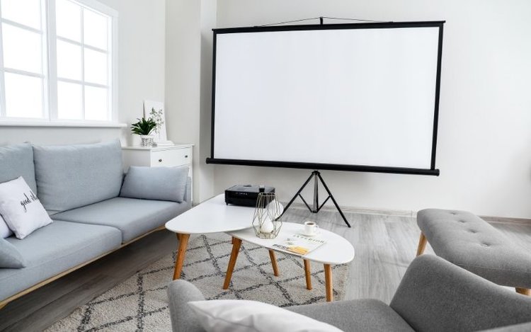 a black projector set in a bright lit living room