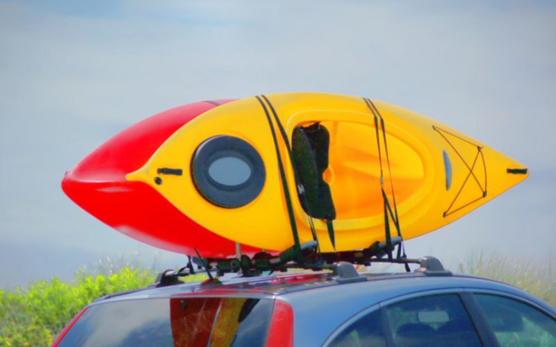 a car carrying kayak on the roof