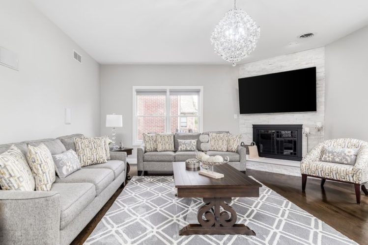 a large TV hang over a fireplace in the modern living room