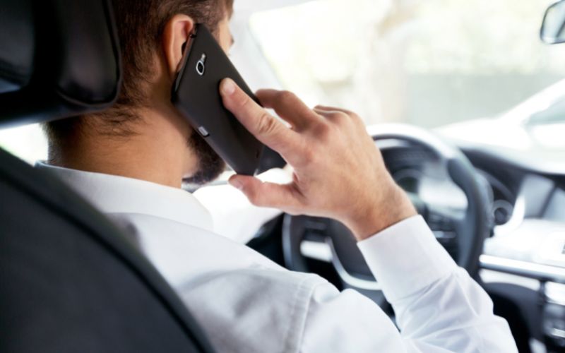 a man talks on the phone while driving