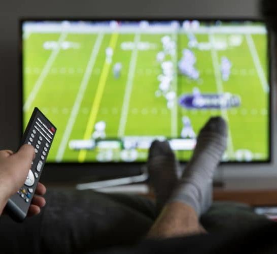 a man watching football on the TV