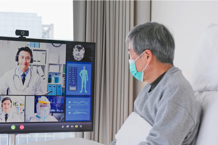 a patient is listening to his health status from doctors via a TV in room