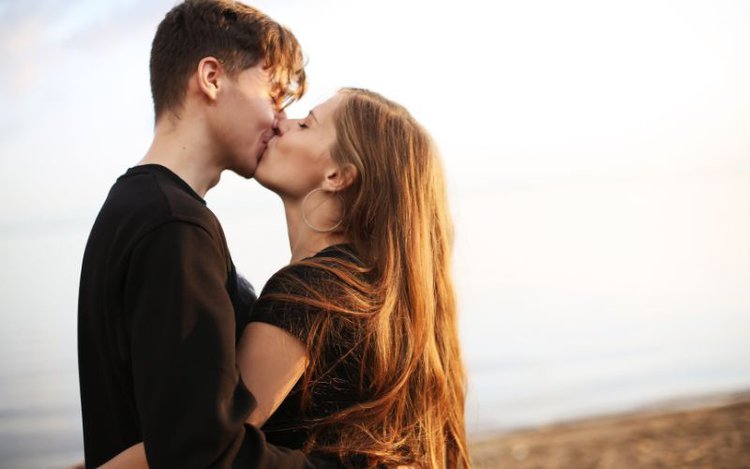 actors kissing near a beach