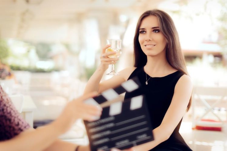 an actress holding a glass of wine in a movie scene
