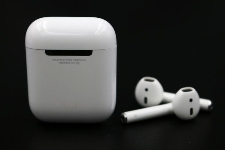 back view of airpods charging case and airpods in black background