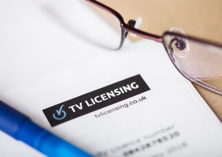 close up view of TV license with glasses and pen