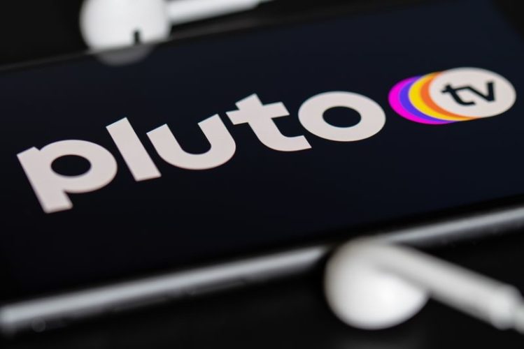 logo of Pluto TV on the phone screen with blurred headphones