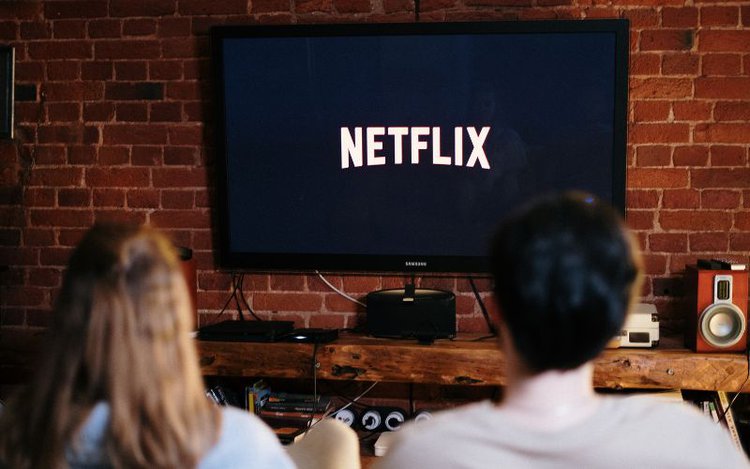 man and woman are watching Netflix on TV together