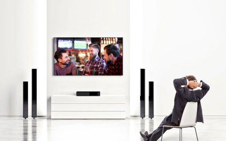 man watching TV with scene of friends drinking beer at a bar