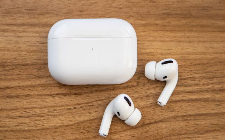 white Airpods and its case in wooden background