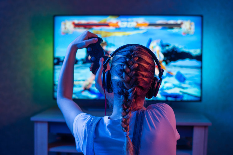 A girl playing game on TV with console control