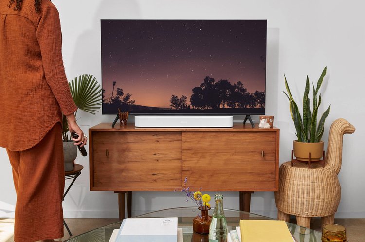 A person is standing watching a TV