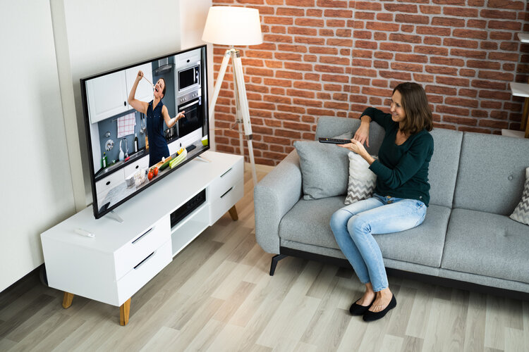 A woman watchs TV in her living room