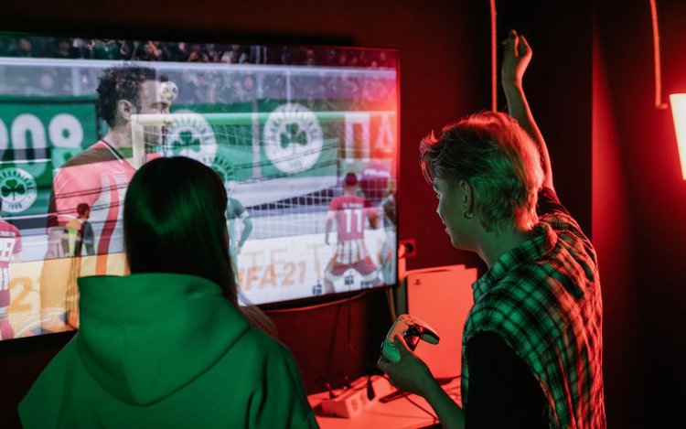 Boy and girl are playing video games on a big tv