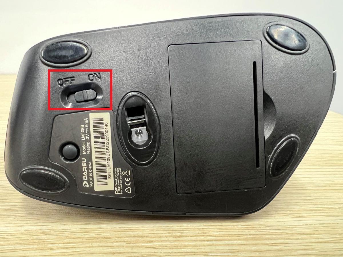 The On and Off button under a wireless computer mouse