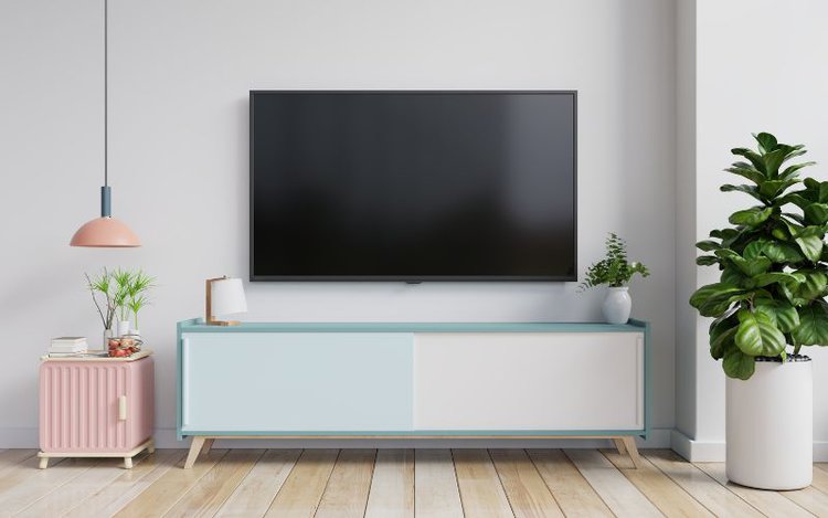 a TV mounted on the wall with the TV stand below it