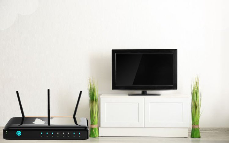 a black wifi router near the TV stand