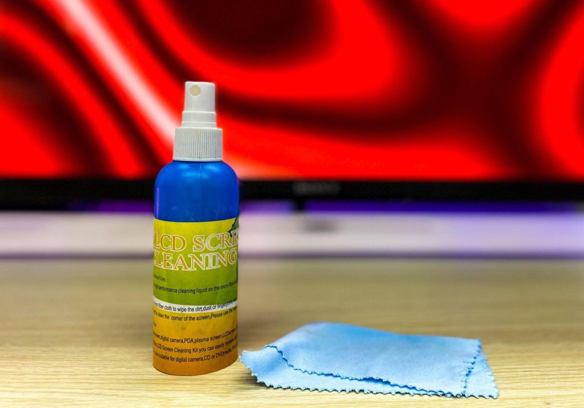a bottle of eyeglass cleaner and a microfiber cloth placed in front of a Sony TV