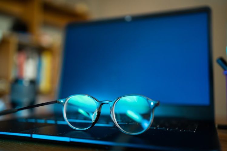 a close-up view of blue light glasses on a laptop