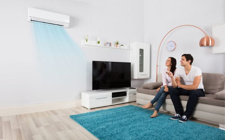 a couple in a room with air conditioner placed near the tv