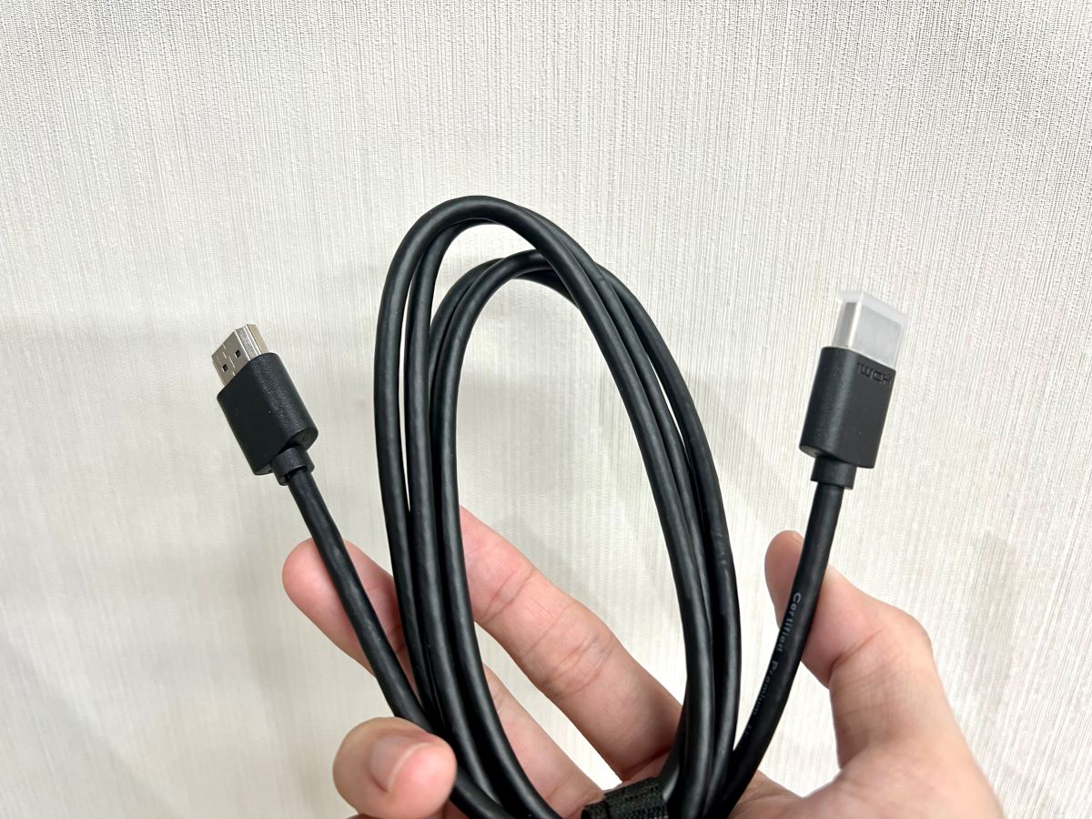 a hand holding an hdmi cable