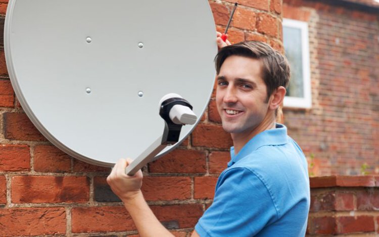 an engineer installs TV satellite dish