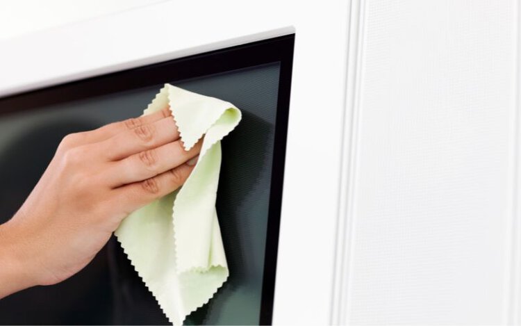 cleaning a tv screen with dry microfiber cloth