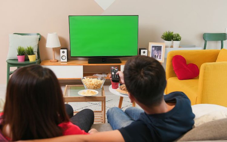 couple with a green TV screen in the living room